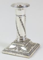 An Edwardian silver candlestick embossed with husk