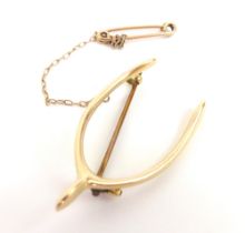 A 15ct gold wishbone brooch, with safety chain, 4.