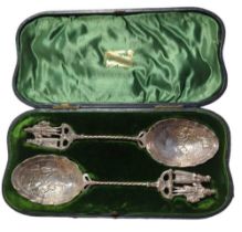 A pair of Continental silver berry spoons, the bowls each embossed with figures