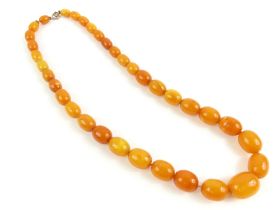 A row of graduated oval butterscotch amber beads,