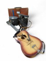 A guitar, cased binoculars and a briefcase