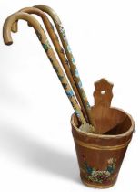 Three souvenir wooden walking sticks, each with at