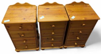 A set of three orange pine bedside cabinets, each