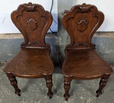 A pair of Victorian mahogany hall chairs, with shi