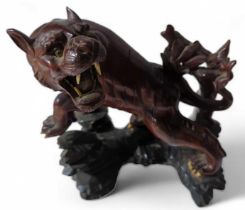 A Japanese carved hard wood figure of a snarling t