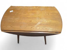 An Ercol light wood oval drop flap table on