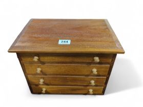 A wooden collectors cabinet of four drawers, 27cms