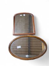 An oval walnut framed wall mirror together with an