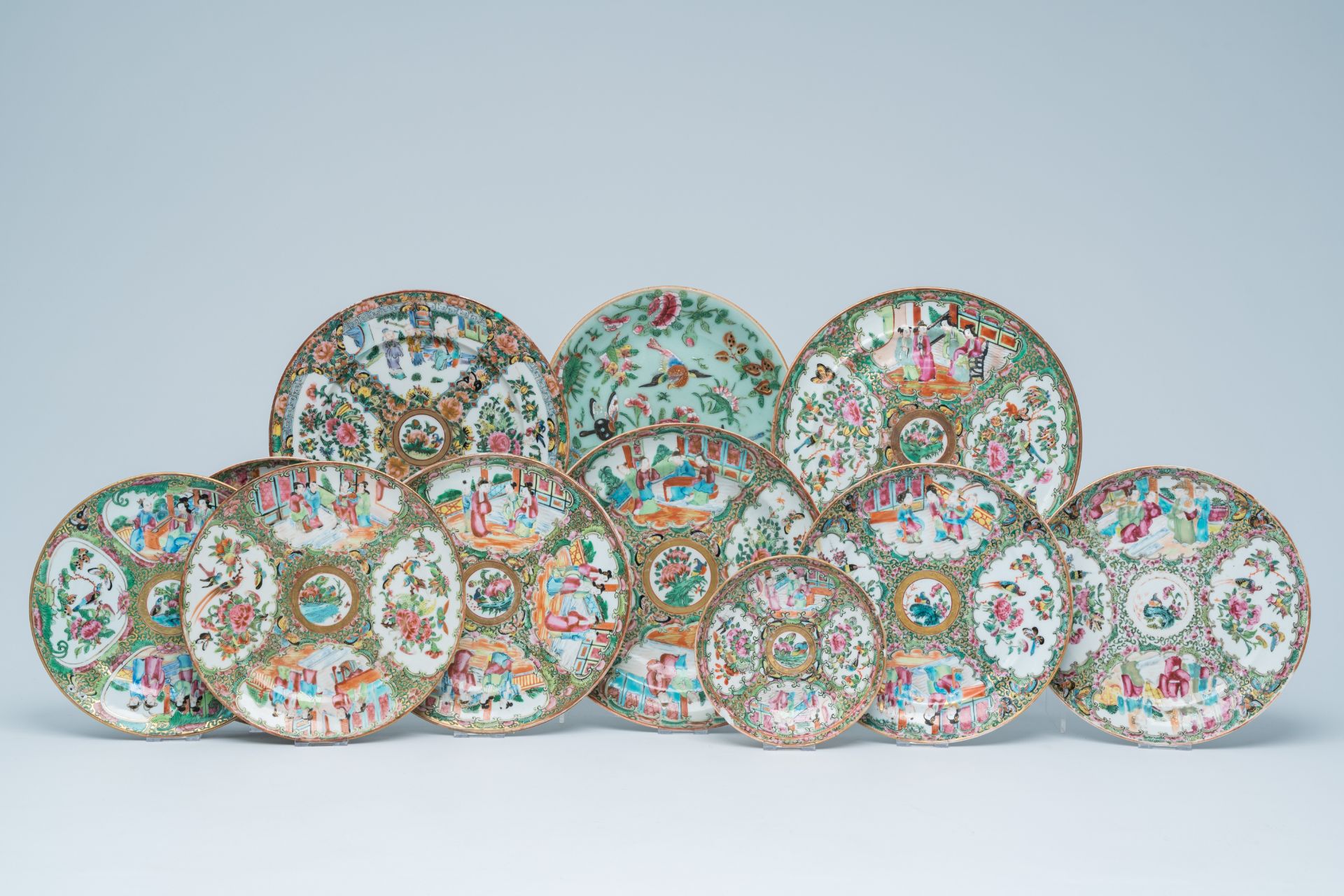 Eleven Chinese Canton famille rose plates with palace scenes and birds and butterflies between bloss