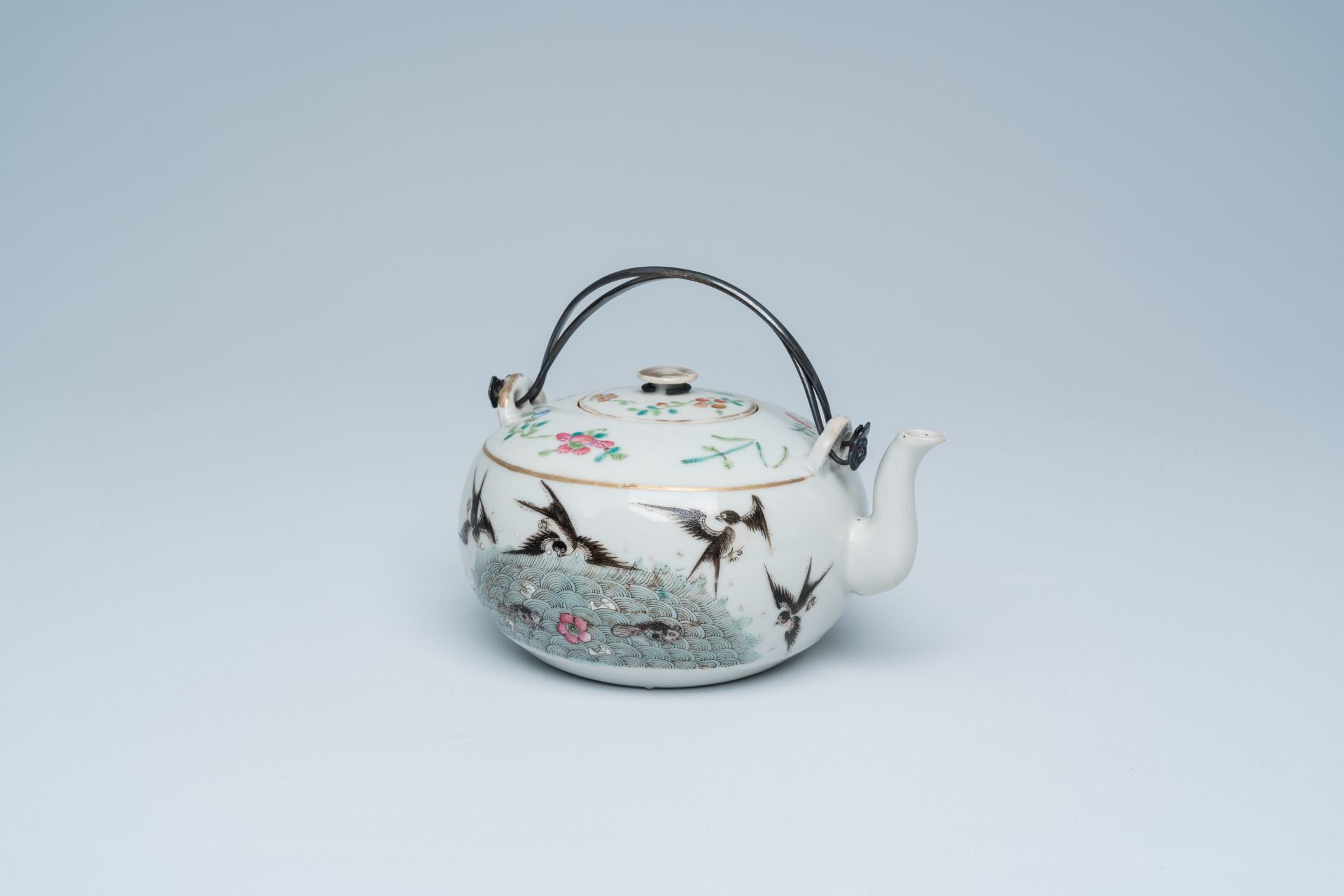 A Chinese famille rose teapot and cover with swallows and butterflies among blossoming branches, 19t