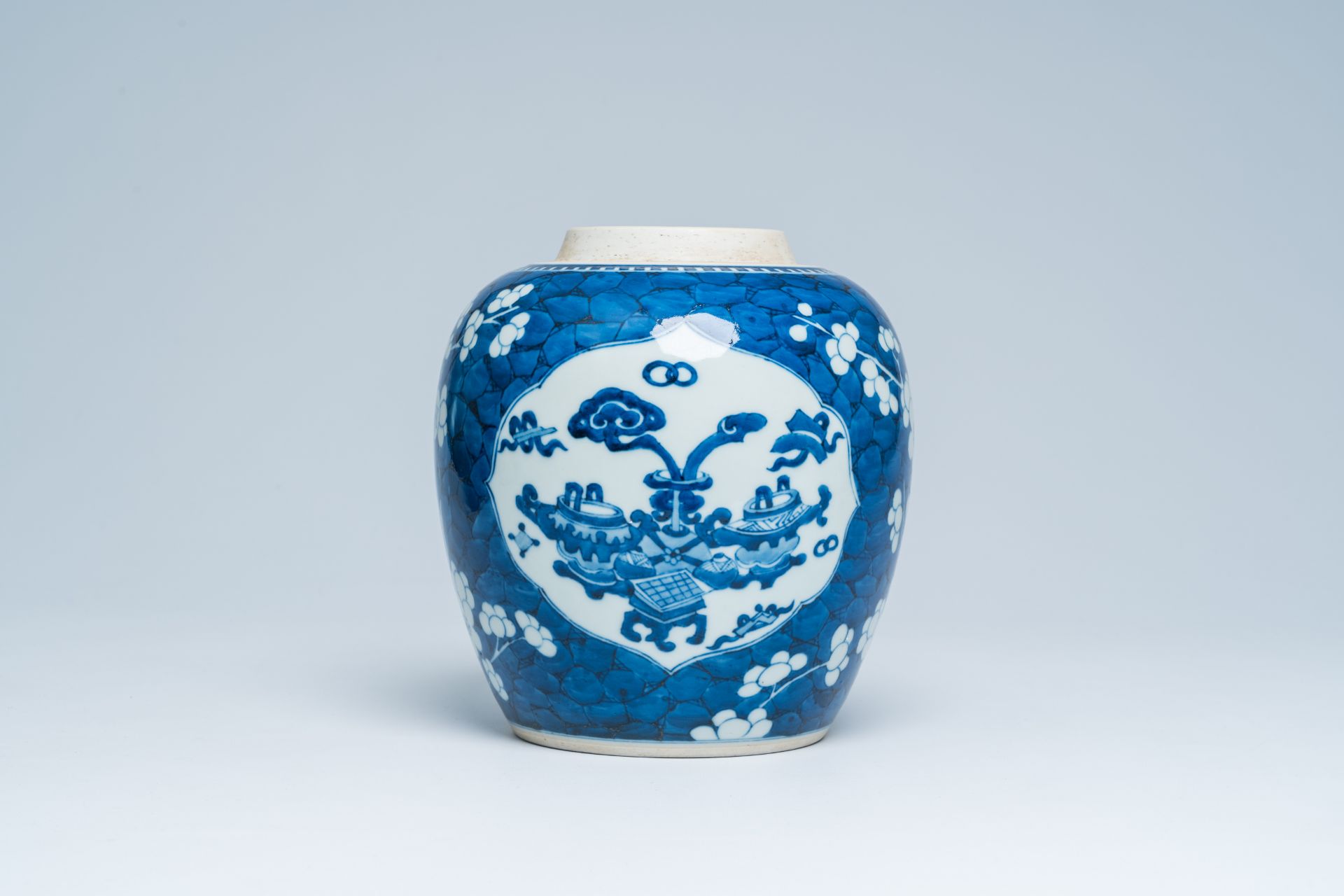 A Chinese blue and white prunus on cracked ice ground ginger jar with antiquities, 20th C.