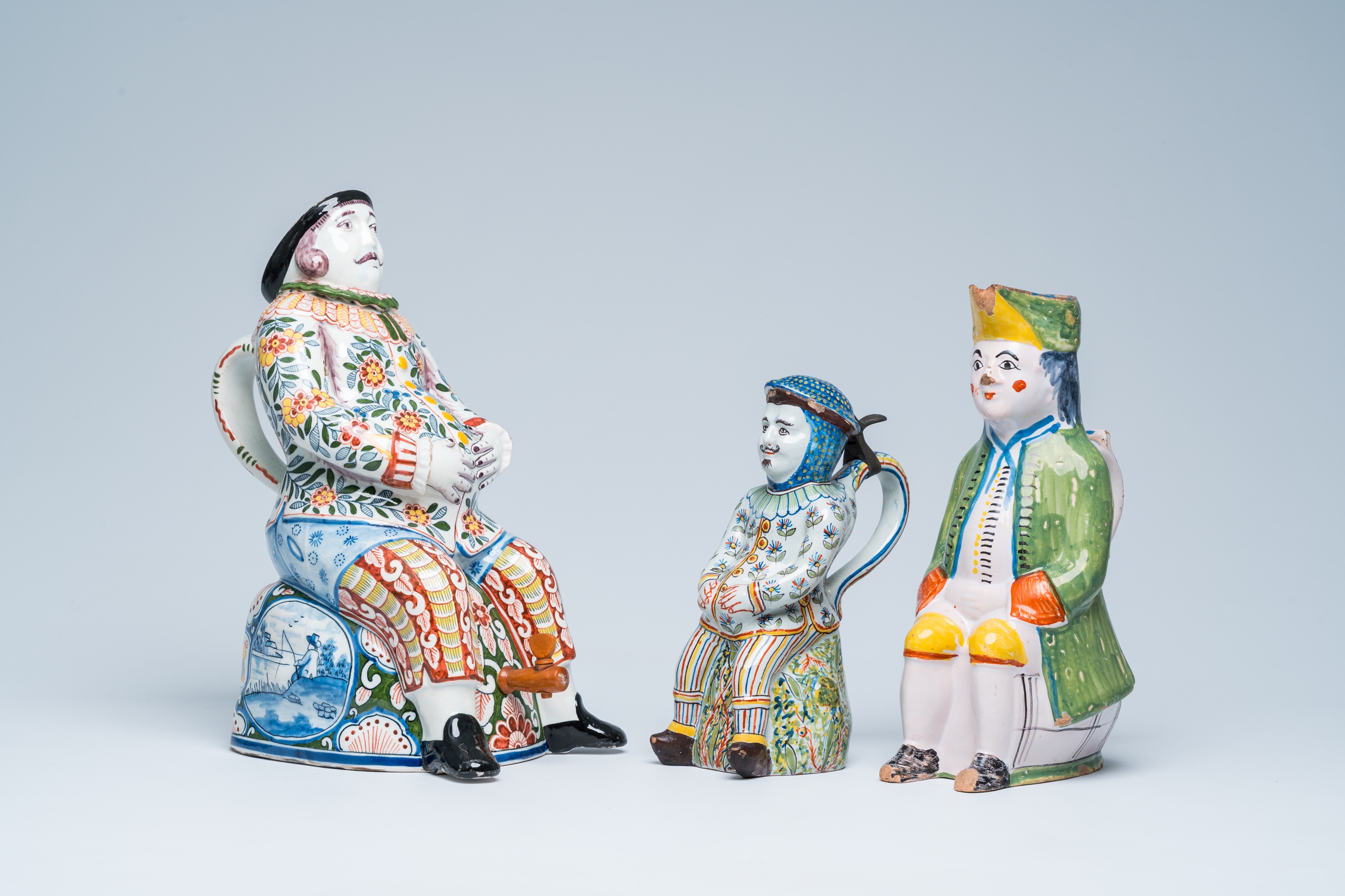 Three polychrome Delft and French faience 'bobbejak' jugs in the shape of men, 19th C.