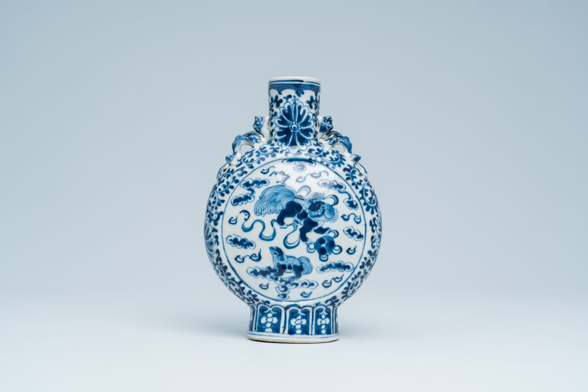 A Chinese blue and white moon flask with Buddhist lions and floral design, 19th C.