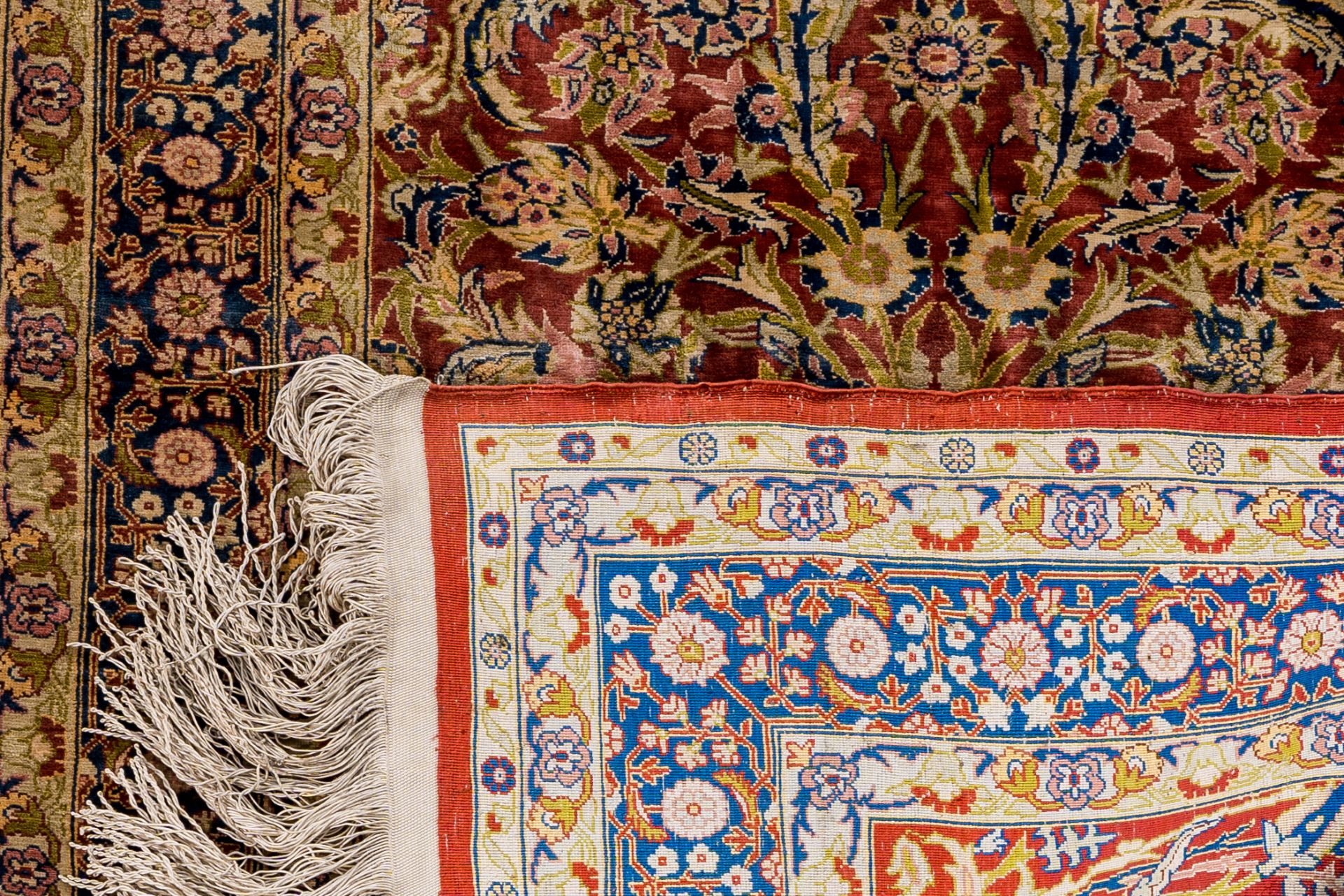 A Turkmen Tekke rug, wool on cotton, and an oriental rug with floral design, silk on cotton, 20th C. - Image 3 of 4