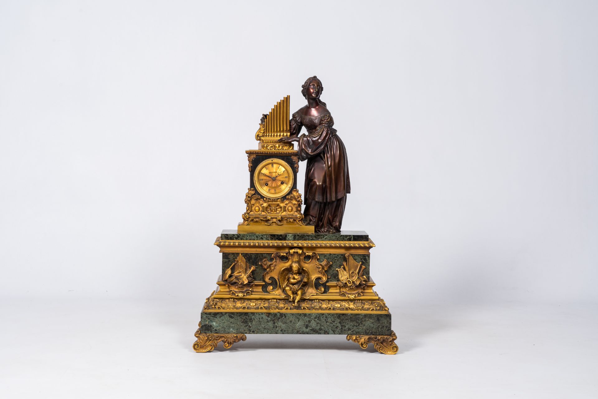 A French patinated and gilt bronze mounted vert de mer marble mantel clock crowned with Saint Cecili