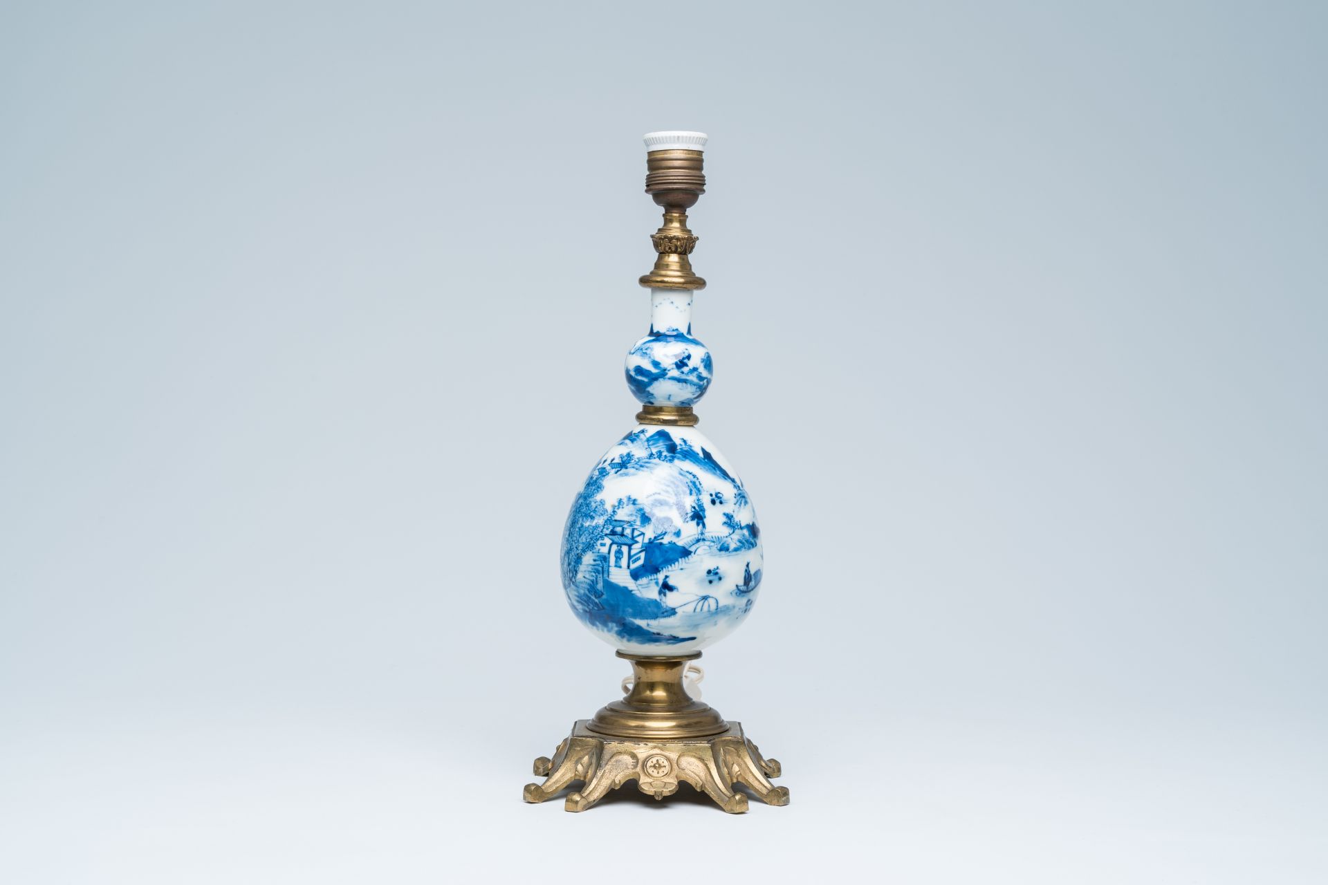 A Chinese blue and white bottle shaped vase with an animated river landscape mounted as a lamp, 19th