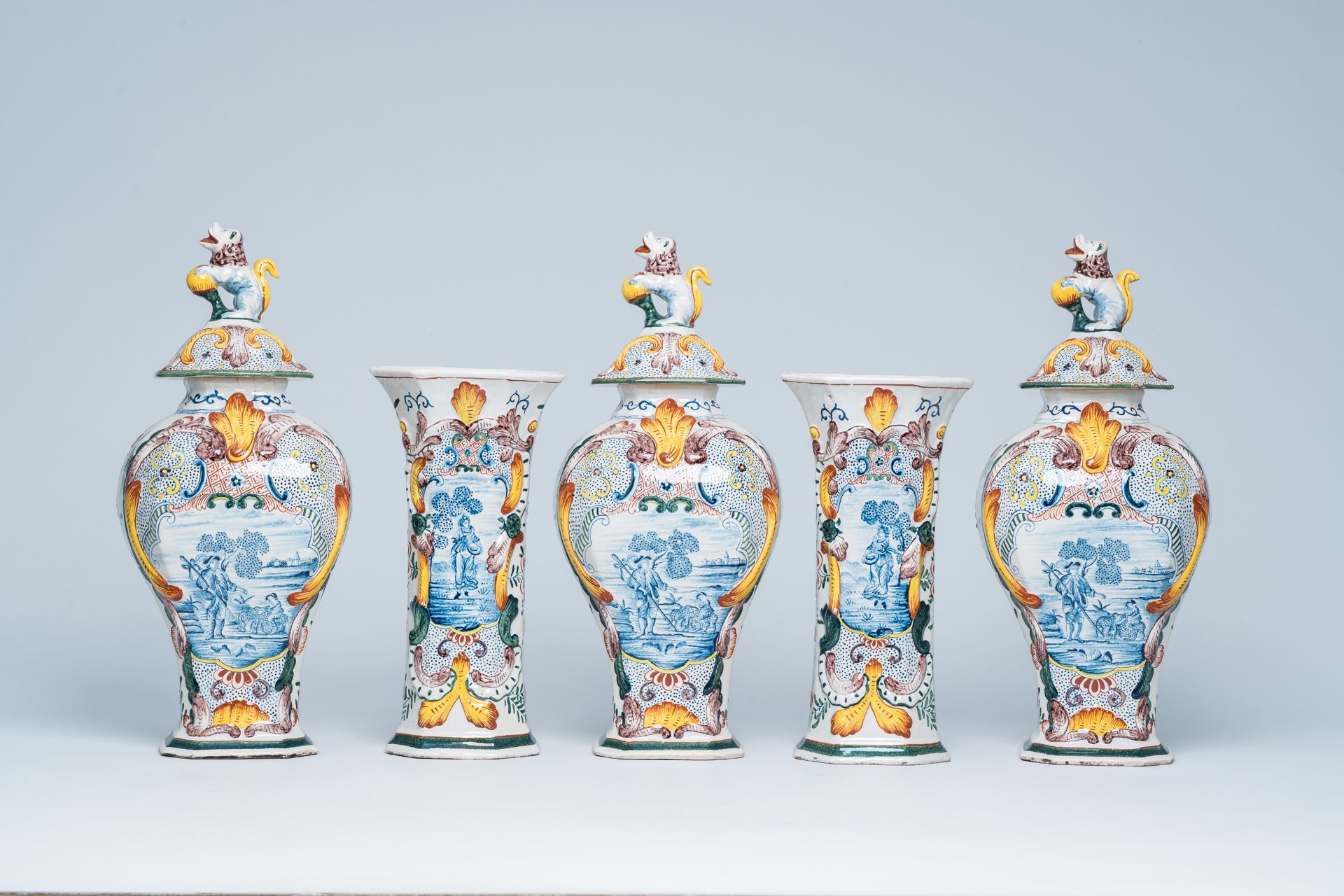 A Dutch Delft polychrome five-piece vase garniture with animated scenes, 19th C.