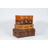 Three various leather travel cases and a steamer trunk with labels of various travel destinations, e