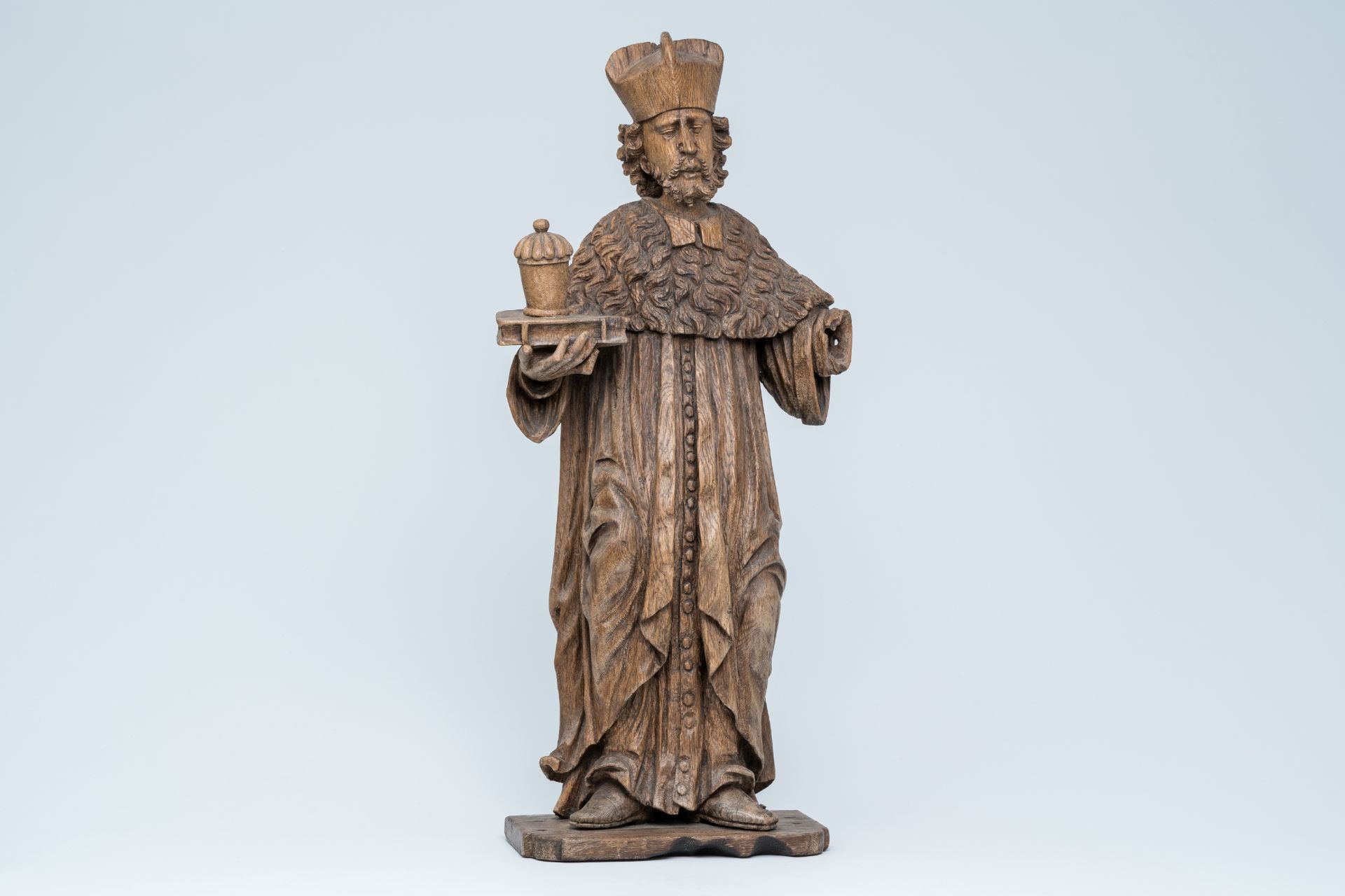 A large wood sculpture of Saint Damian holding a book and an ointment jar, Central Europe, 17th C.