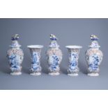 A large Dutch Delft polychrome five-piece garniture with floral design and figures in a landscape, 1
