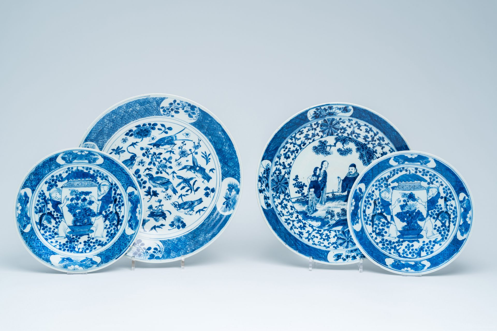 Four Chinese blue and white chargers with figures and birds among blossoming branches, 19th C.