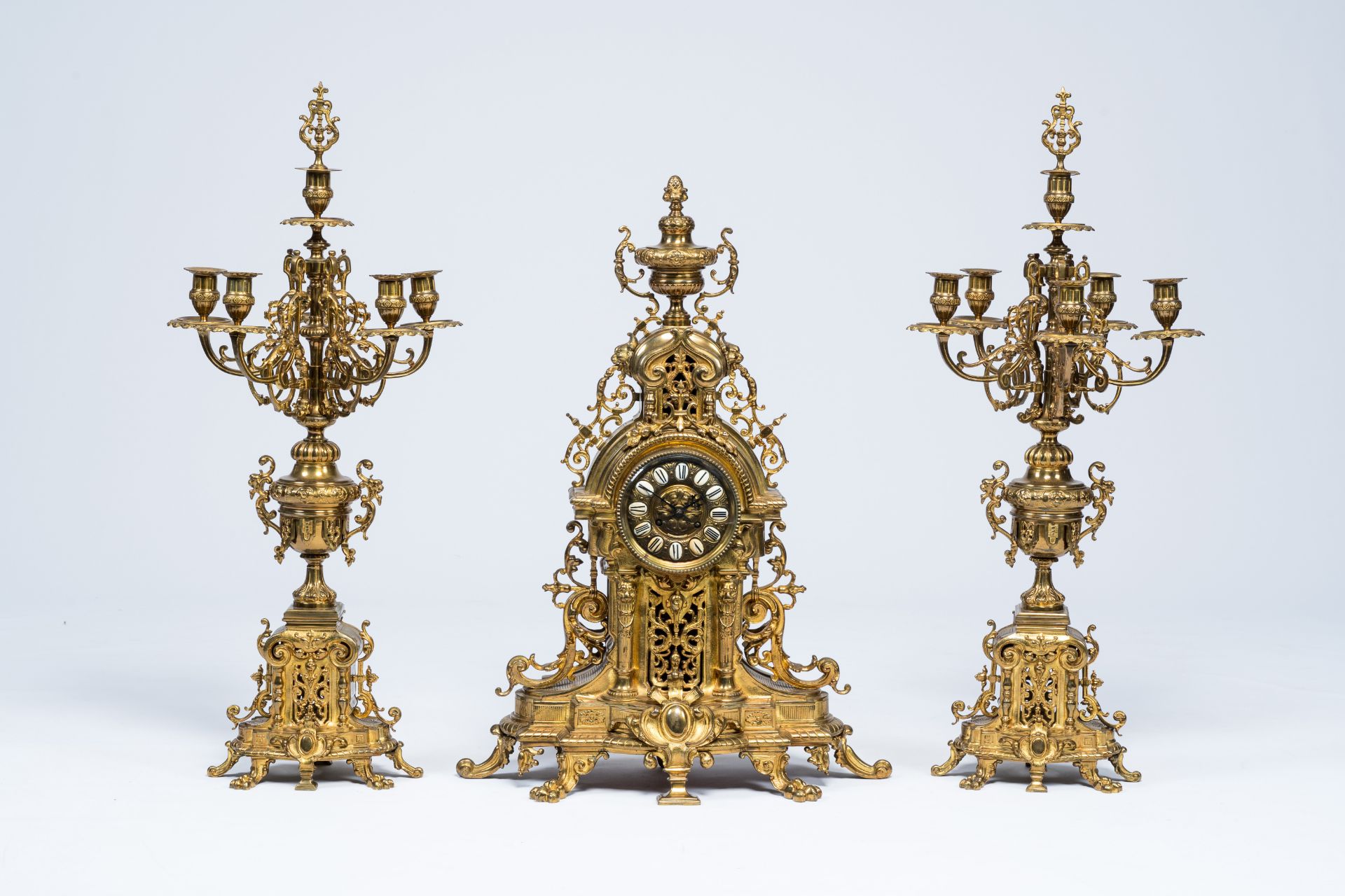 A large Belgian-French Baroque revival gilt brass three-piece clock garniture, late 19th C.