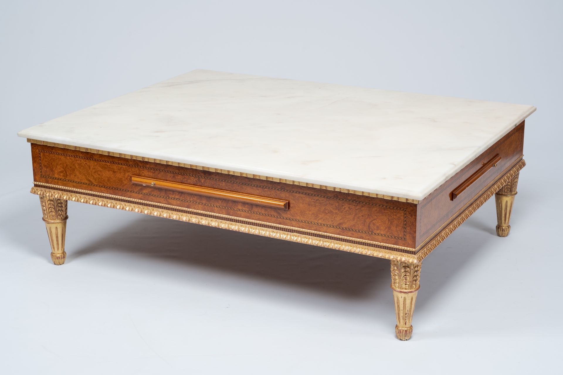 A Neoclassical partly gilt wood coffee table with marble top and four extendable plateaus, 20th C.