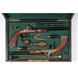 A dueling case with a pair of French pistols with carved wood butts, engraved locks and deep blue ba