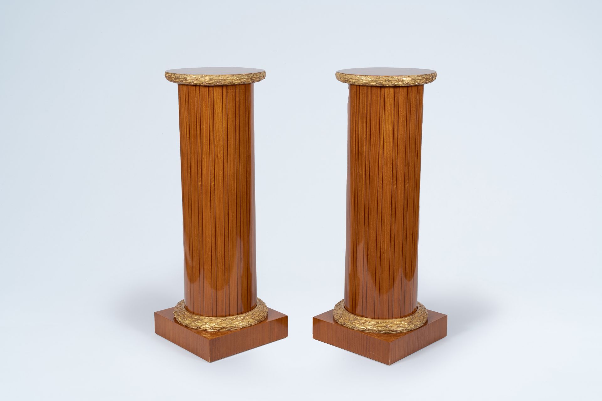 A pair of Neoclassical partly gilt wood pedestals with marquetry and floral design, 20th C.