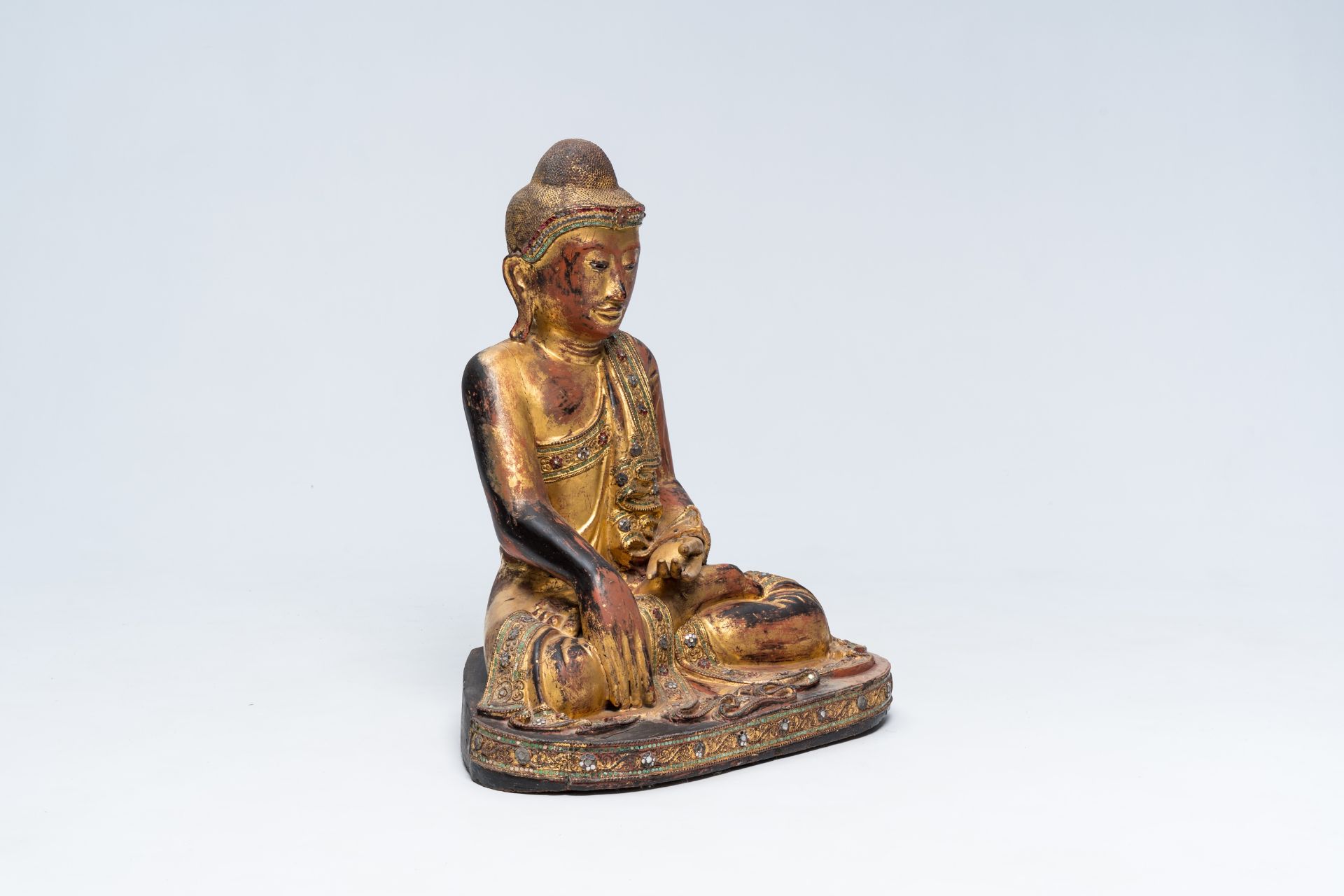 A tall inlaid gilt wood figure of a seated Buddha, Burma or Thailand, 20th C.