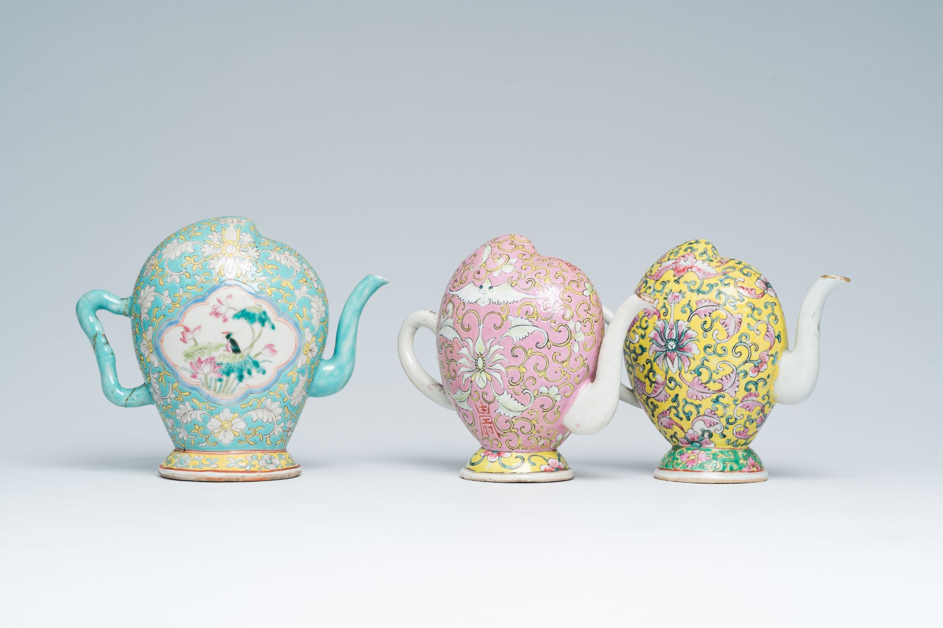 Three Chinese famille rose peach-shaped cadogan teapots with floral design, 19th C.
