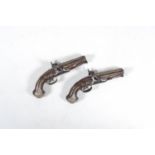 A pair of French two-barrelled silver mounted percussion pistols with walnut gunstocks and silver in