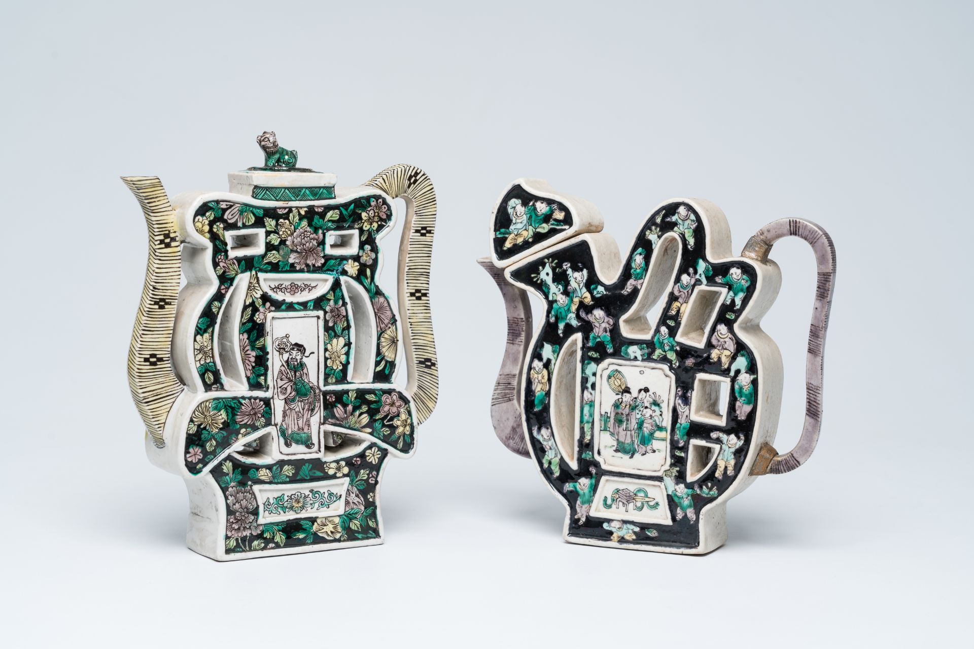 Two Chinese famille noire biscuit 'puzzle' teapots and covers with figures in a landscape and floral