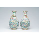 A pair of Chinese Canton famille rose celadon ground 'Eight Immortals' vases with a palace scene and