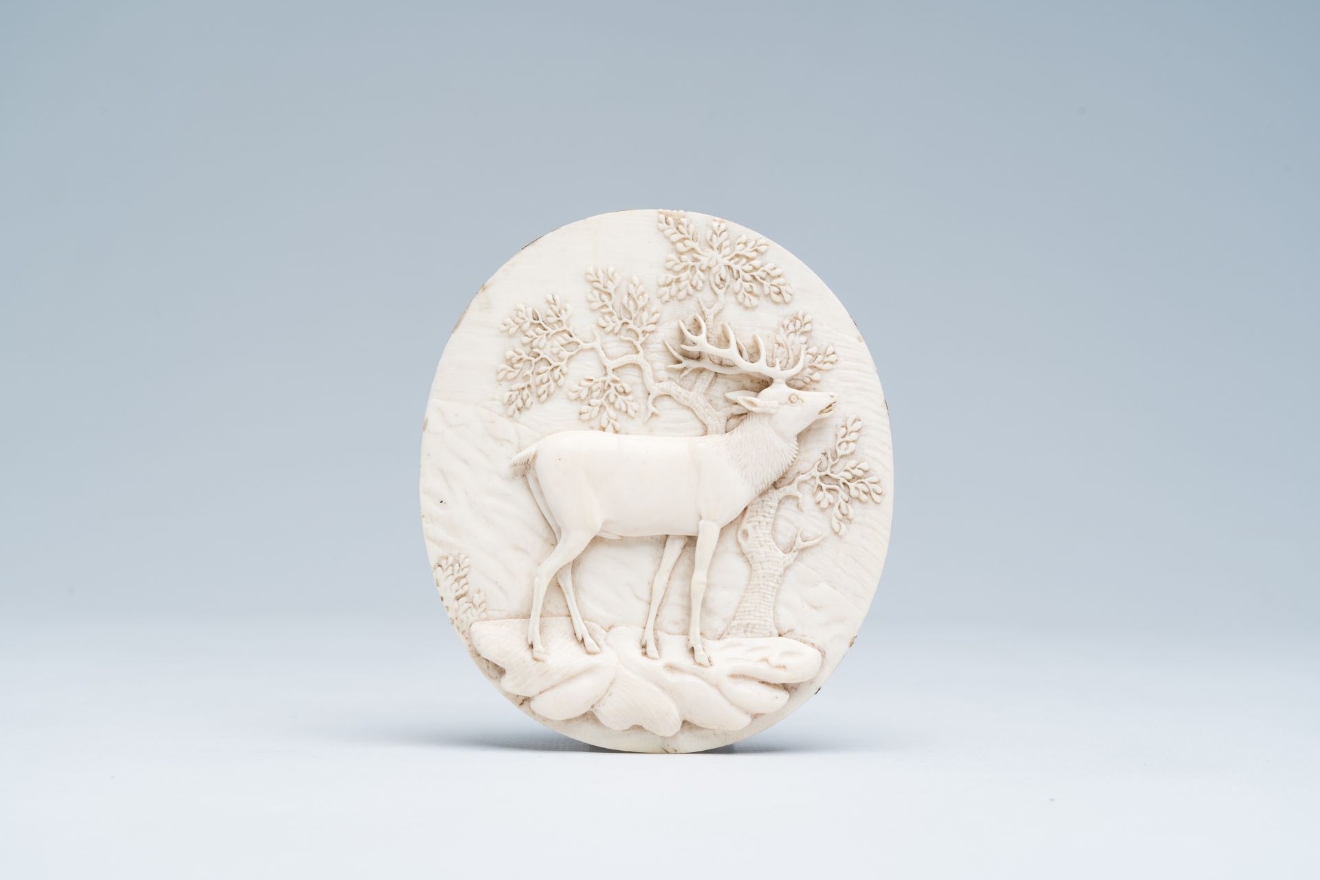 A German or Austrian basso relievo ivory plaque with a deer on a rock in a forest, late 19th C.