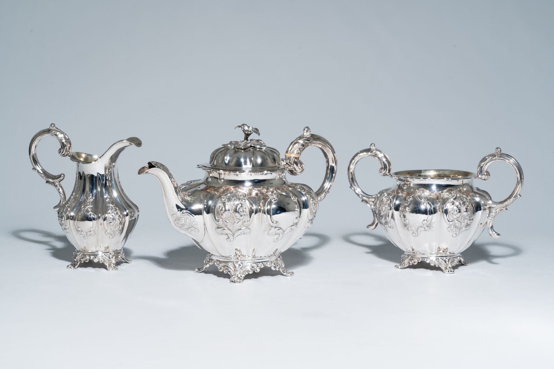 A three-piece English Victorian silver tea set with floral relief design, maker's mark Hayne and Car