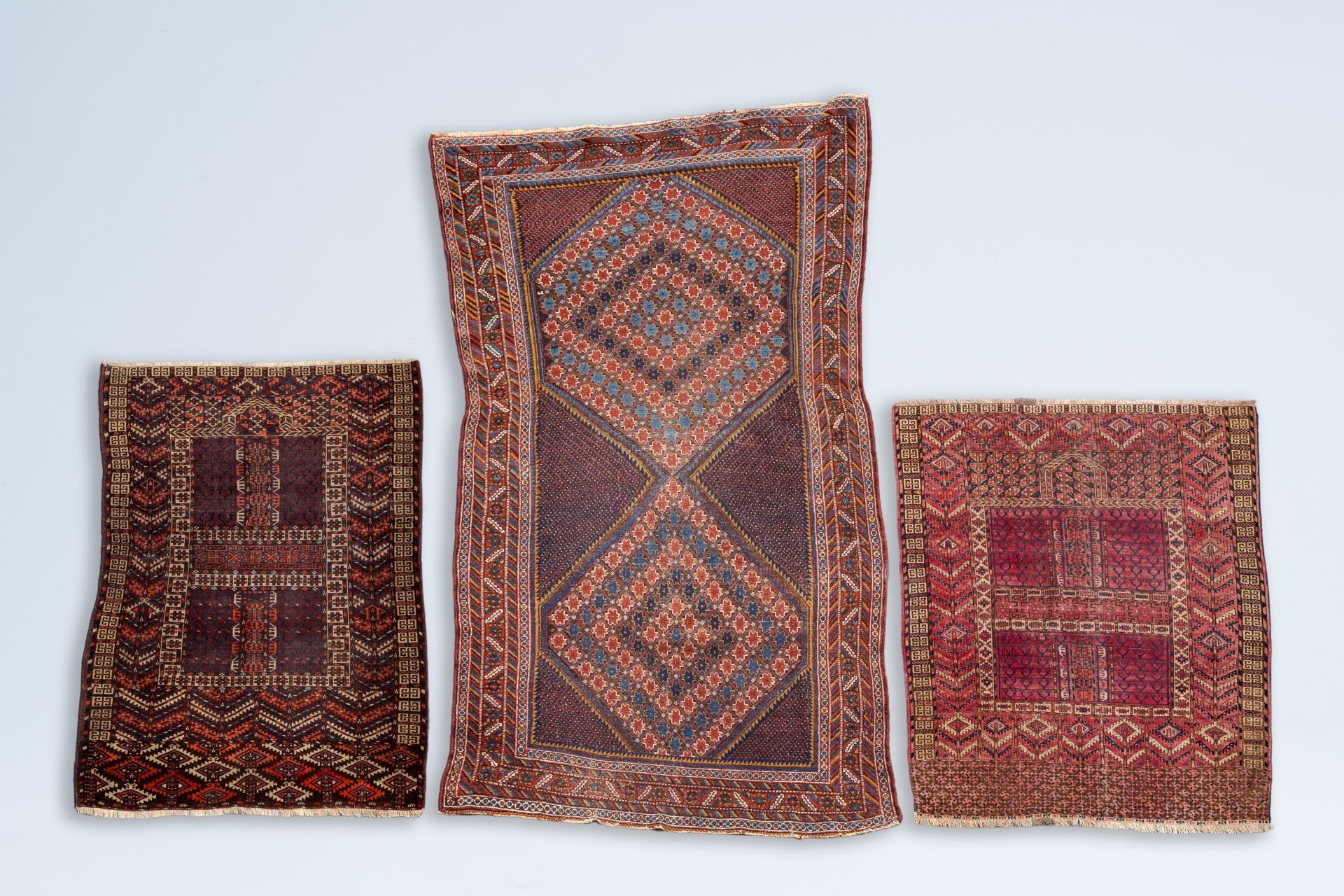 Two Turkmen prayer rugs with stylized motifs and a Persian Khamseh rug, wool on cotton, first half 2