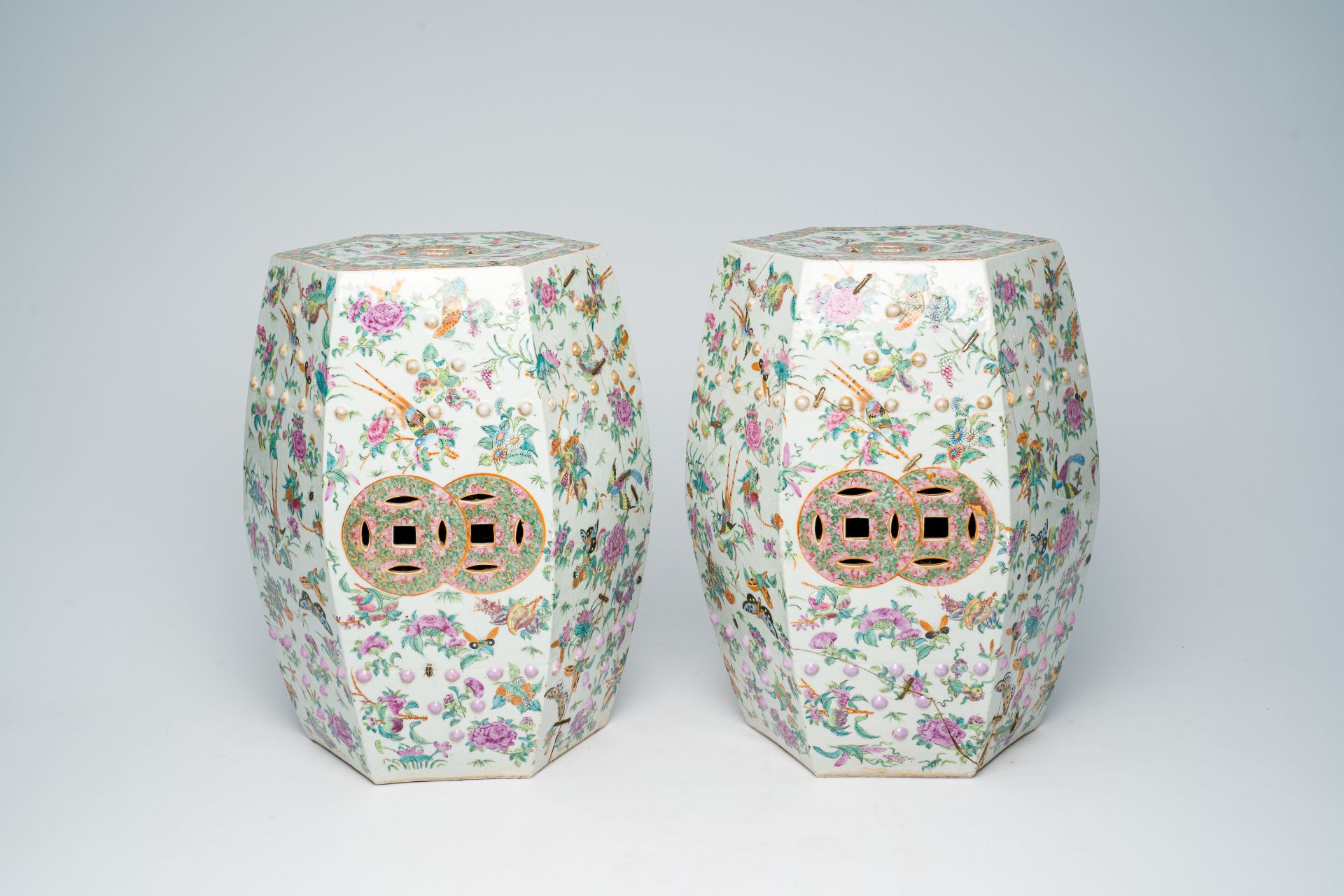 A pair of Chinese Canton famille rose hexagonal garden seats with birds, butterflies and insects amo