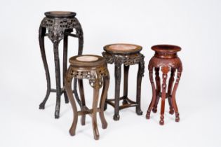 Four Chinese open worked carved wood stands, three of which with marble tops, 20th C.