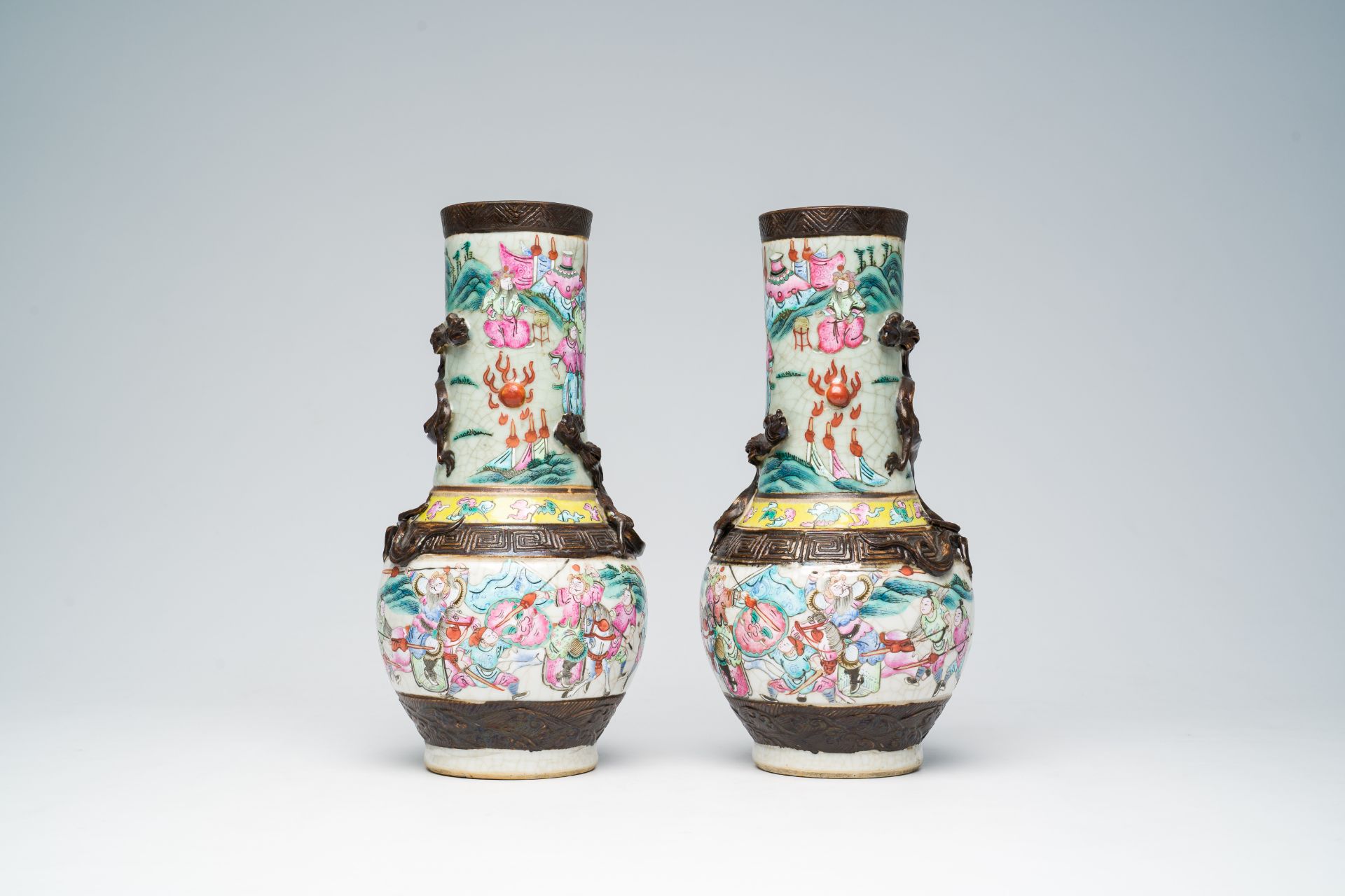 A pair of Chinese Nanking crackle glazed famille rose 'warrior' vases with dragons chasing the pearl