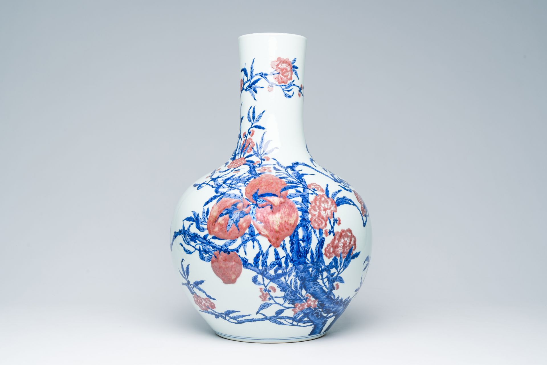 A Chinese blue, white and copper-red 'nine peaches' tianqu ping vase, Qianlong mark, 20th C.