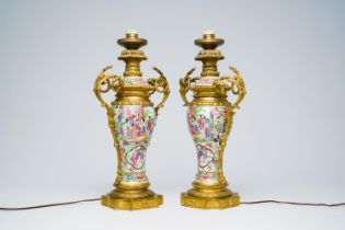 A pair of Chinese Canton famille rose vases and covers with palace scenes and floral design mounted