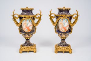 A pair of French gilt mounted gold layered blue ground Sevres style vases with landscapes and the li