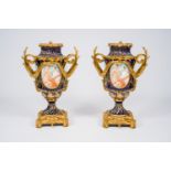 A pair of French gilt mounted gold layered blue ground Sevres style vases with landscapes and the li