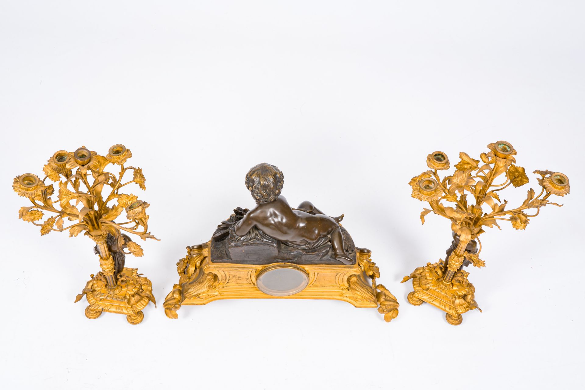 A French gilt and patinated bronze three-piece clock garniture crowned with a putto playing with a b - Image 4 of 5