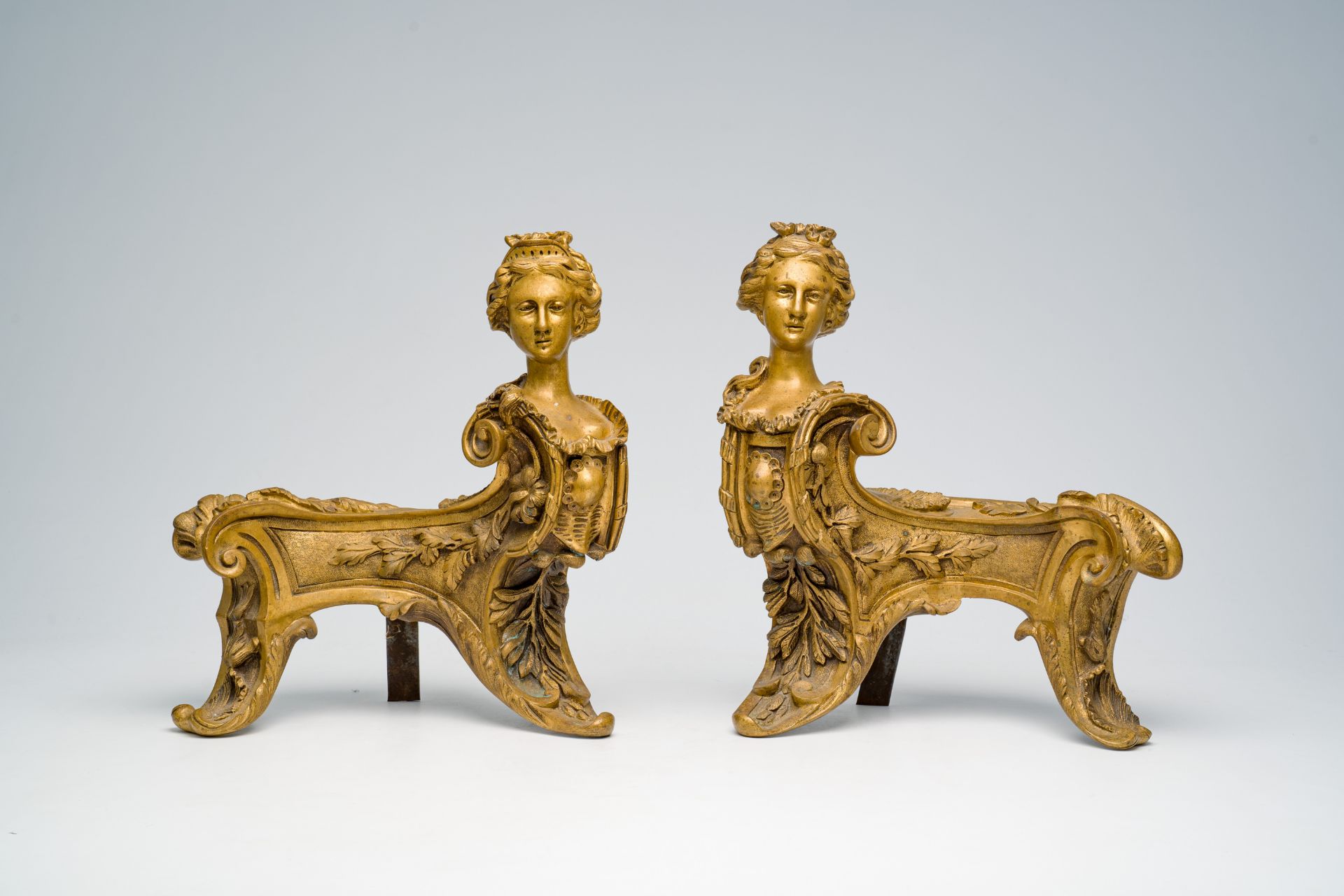 A pair of French Louis XIV style bronze andirons crowned with a regal lady's bust in the manner of F