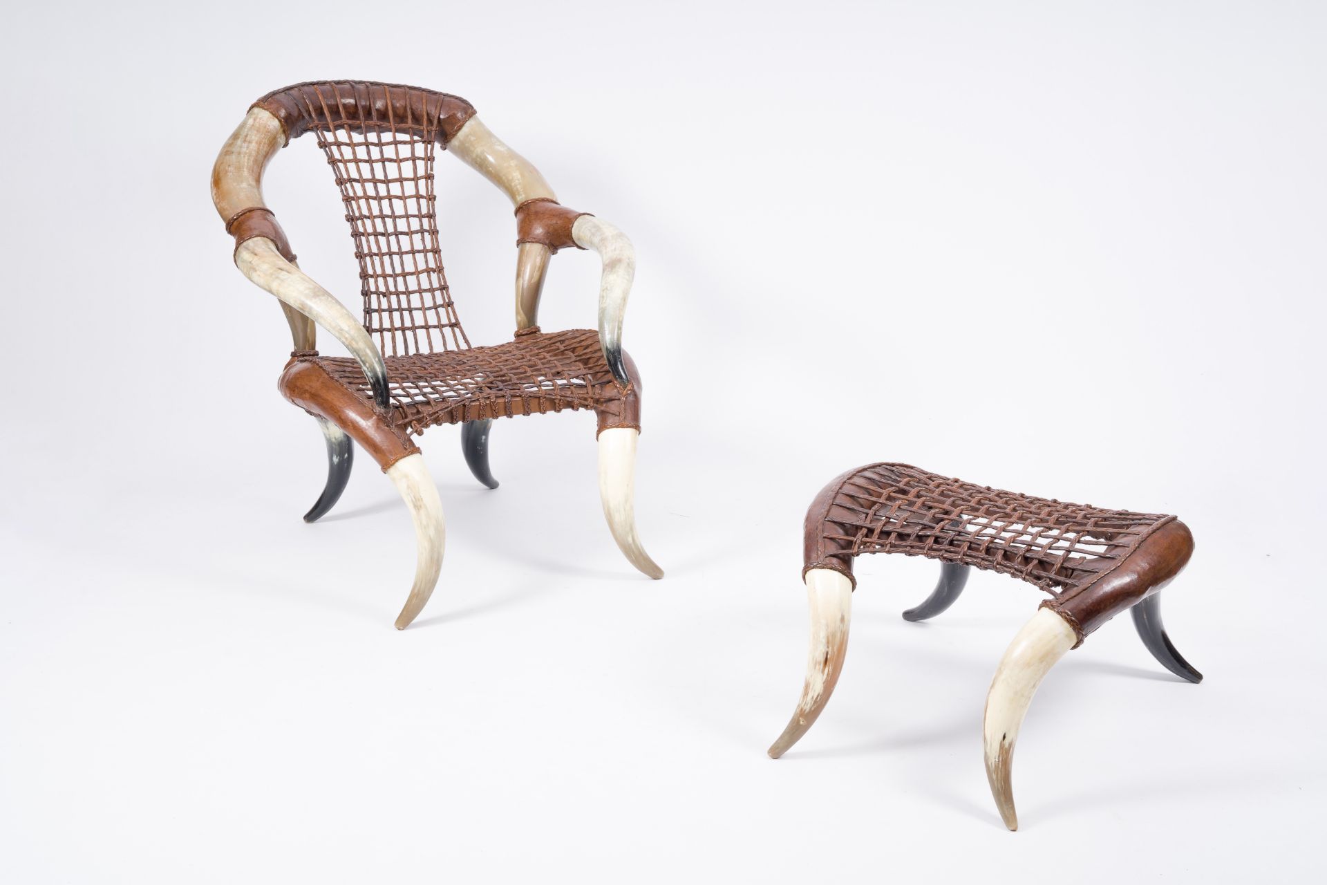 In the manner of Michel Haillard (1959): A leather and horn armchair and matching ottoman, second ha