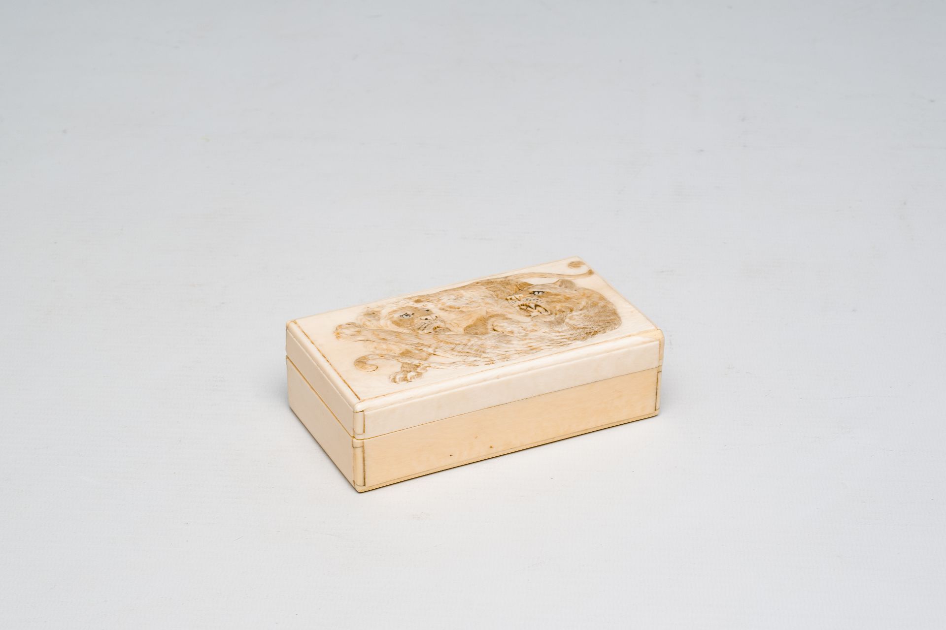 A rectangular Japanese ivory box and cover with a basso relivo fight between a lion and a tiger, Mei - Image 2 of 9