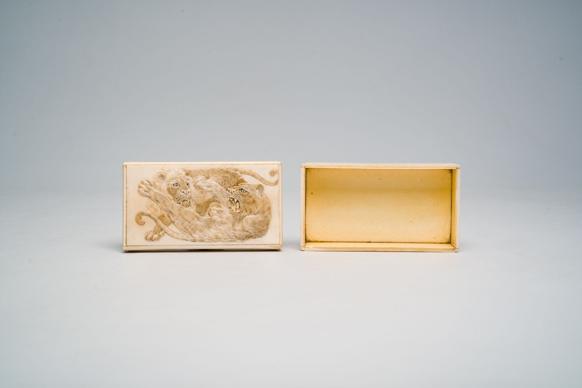 A rectangular Japanese ivory box and cover with a basso relivo fight between a lion and a tiger, Mei - Image 4 of 9