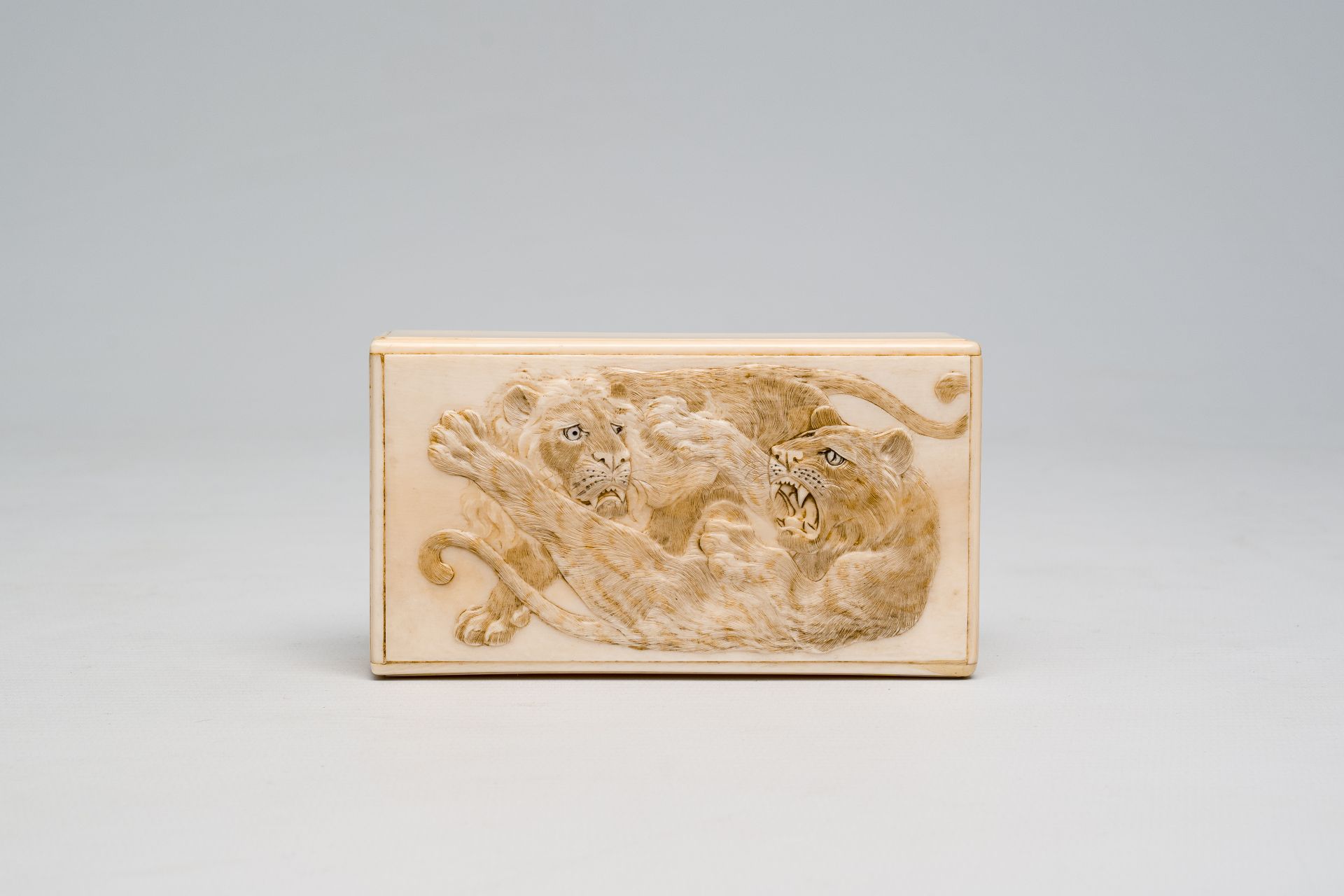 A rectangular Japanese ivory box and cover with a basso relivo fight between a lion and a tiger, Mei - Image 3 of 9